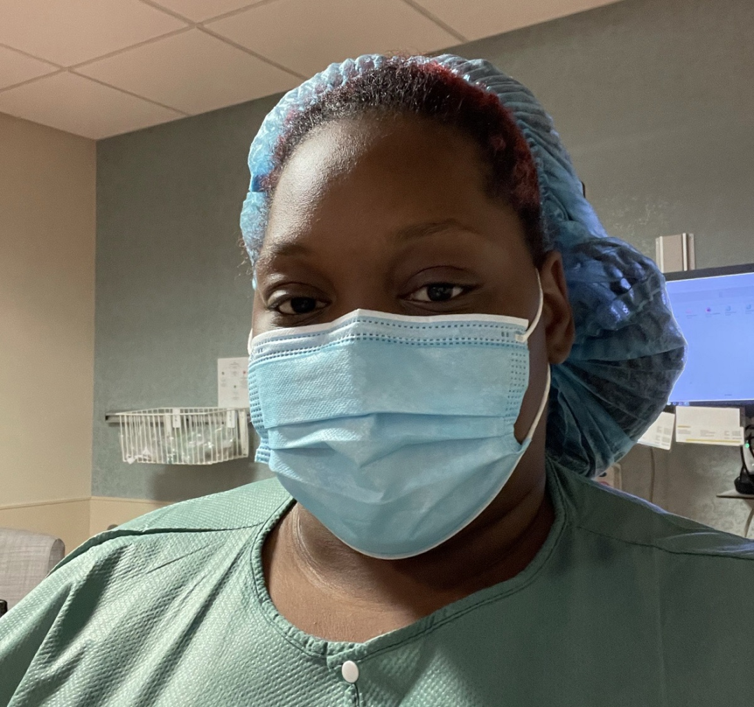 Iyanna Bridges wears a surgical mask, cap, and scrubs in a hospital